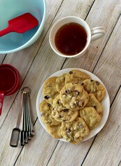 Freshly made homemade chocolate chip cookies warm from oven ready to eat with baking equipment background