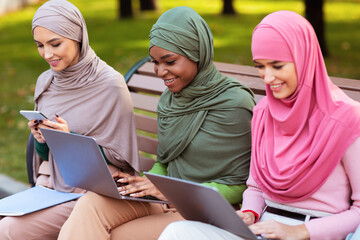 Muslim Students Women Using Gadgets Learning Online Sitting In Park