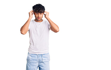Fototapeta premium Young hispanic man wearing casual clothes with hand on head for pain in head because stress. suffering migraine.