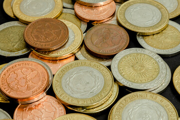 Different argentine coins stacked. Pile of money. Metal coins texture. Financial world background.
