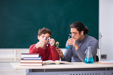 Young male teacher and schoolboy in the classroom
