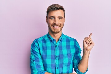 Handsome caucasian man wearing casual clothes smiling happy pointing with hand and finger to the side