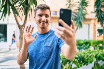 Young caucasian man smiling happy doing video call using smartphone at the city.