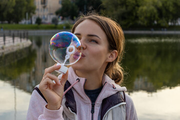 Beautiful woman blowing one big bubble and smiling
