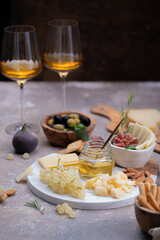 Marble Cheese board with delicous cheeses, nuts, honey and grapes
