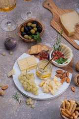 Fototapeta na wymiar Marble Cheese board with delicous cheeses, nuts, honey and grapes
