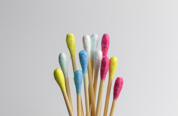 Wooden colored ear swabs closeup. White yellow blue pink diversity and equality