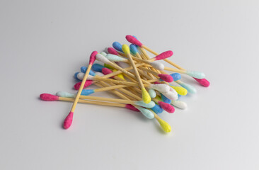 Heap of colorful wooden cotton ear swabs or ear sticks with white background.  Happy mood in everyday routine with bright colours. isolated.