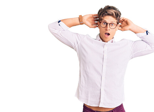 Young handsome man wearing business clothes and glasses crazy and scared with hands on head, afraid and surprised of shock with open mouth