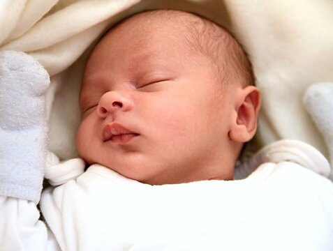 little baby wrapped in blanket sleeping in bed at home stock photo