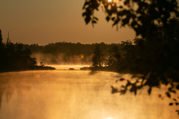 Morgennebel am See im goldenen Licht