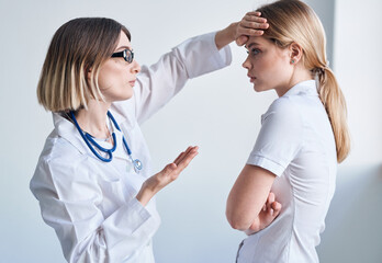 Doctor in a medical gown measure the temperature of a female patient providing medicine services