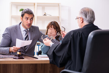 Young woman in courthouse with judge and lawyer