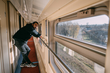 The man looks out the window on the train