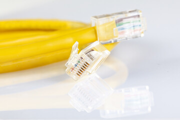 Network ethernet cable with RJ45 connectors isolated on white background. UTP Cable or LAN Cable. yellow color on white background. Close up