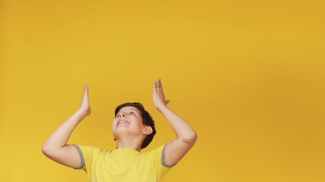 Special offer. Impressed kid. Perfect solution. Knowledge discovery. Surprised amused enthusiastic young boy showing invisible information pointing up at copy space isolated on yellow background.
