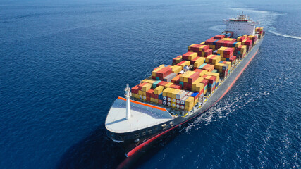 Aerial drone photo of container ship with colourful truck size containers cruising in open ocean...