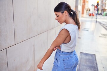 Beautiful young woman wearing fashionable clothes walking down the street