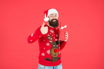Fototapeta na wymiar happy bearded man in warm knitted sweater and santa claus hat celebrate winter holiday of chistmas and feel merry about xmas gift, boxing day