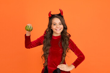 cute to spook. teenage child in imp horns. cheerful kid carry pumpkin. making jack o lantern....