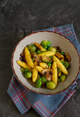 
Bavarian fried finger-shaped potato dumplings with green vegetables and mushrooms
