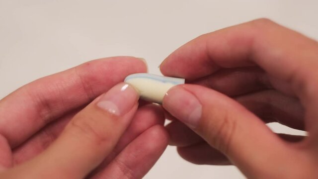 Woman holding earplugs isolated on white background. Concept. Close up of female hands holding soundproof soft earplugs and pressing on them with her fingers.