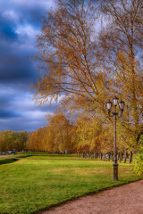 People walk in the autumn park with golden leaves in sunny weather. Kuskovo park in the capital of Russia, Moscow.