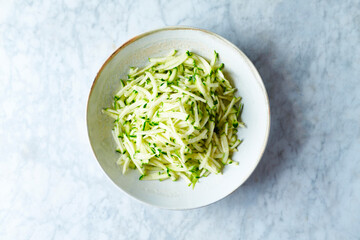Grated zucchini in a ceramic bowl. From to. Healthy cooking