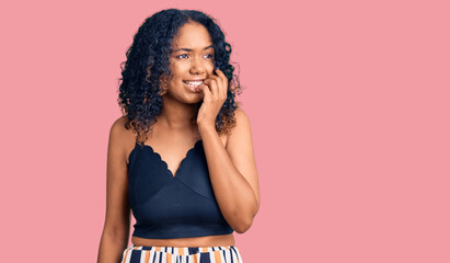 Young african american woman wearing casual clothes looking stressed and nervous with hands on mouth biting nails. anxiety problem.