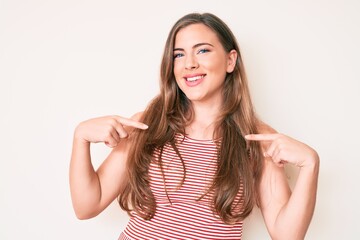 Fototapeta premium Beautiful young caucasian woman wearing casual clothes looking confident with smile on face, pointing oneself with fingers proud and happy.