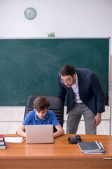 Young male teacher and schoolboy in the classroom