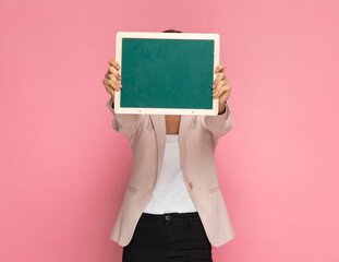businesswoman hiding her face behind a green board