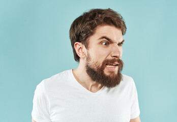 Aggressive man with a beard on a blue background cropped view