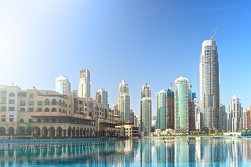 Obraz premium Downtown Dubai skyline in morning with high rise buildings reflected in pool water. United Arab Emirates, UAE.