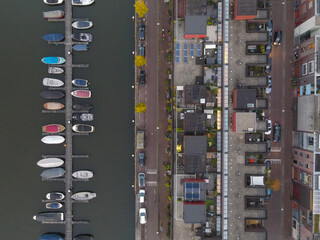 Aerial shot of an urban area houses next to the water with small docks boats
