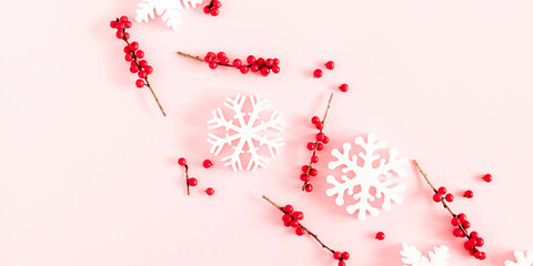 Christmas, winter composition. Xmas decorations, red berries, snowflakes on pastel pink background. Christmas, New Year, winter concept. Flat lay, top view, copy space