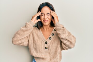 Young beautiful hispanic girl wearing casual winter sweater with hand on head, headache because stress. suffering migraine.