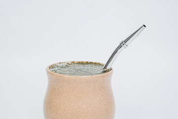 Yerba mate tea in a special vessel and with a drinking tube. The concept of strengthening the body, recharging with energy. Peruvian holly tea, a traditional drink.