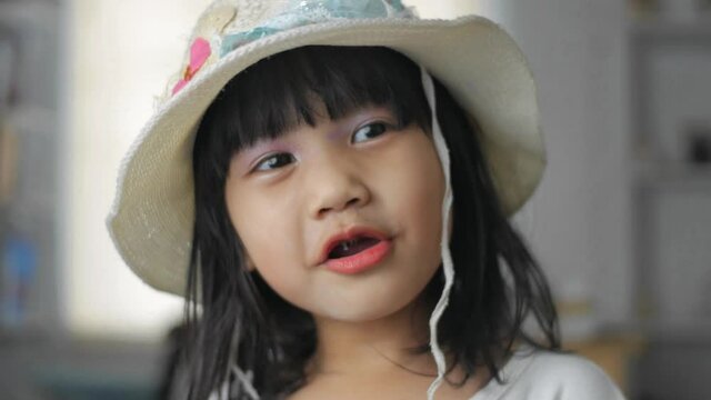 Funny cute Asian baby girl with bright make up singing and dancing