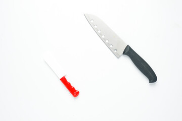 A picture of kitchen knife and toy knife on isolated white background for my ambition concept.