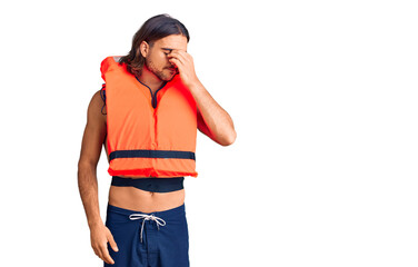 Young handsome man wearing nautical lifejacket tired rubbing nose and eyes feeling fatigue and...