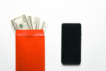 A picture of blank smartphone with envelope filled of fake money on white table. International...