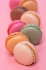 Delicious and colourful macaroons on pink background