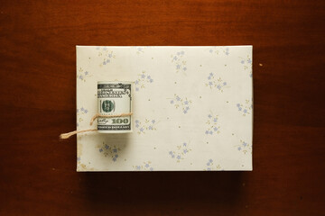 Flatlay picture roll of fake money with gift box for bribery and corruption. International Anti-Corruption Day concept.