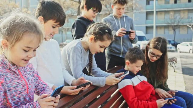 Children are playing on smartphone in the playground