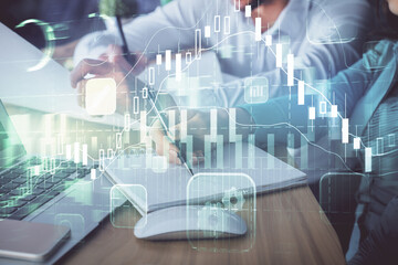 Double exposure of forex chart drawing over people taking notes background. Concept of financial analysis