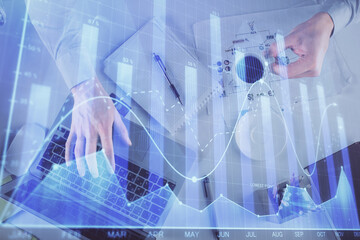 Multi exposure of man's hands typing over computer keyboard and forex graph hologram drawing. Top view. Financial markets concept.