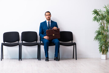 Young businessman waiting for an interview at hall