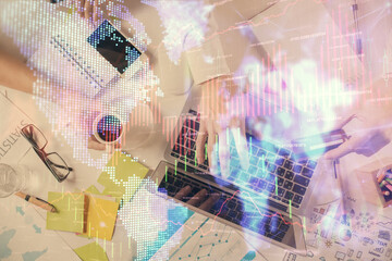 Multi exposure of man's hands typing over computer keyboard and forex graph hologram drawing. Top view. Financial markets concept.