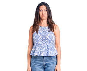 Obraz premium Young beautiful brunette woman wearing casual t-shirt puffing cheeks with funny face. mouth inflated with air, crazy expression.